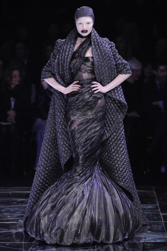 A model walks the "Horn of Plenty" runway in a dress made of garbage bags and a coat made of bubblewrap.