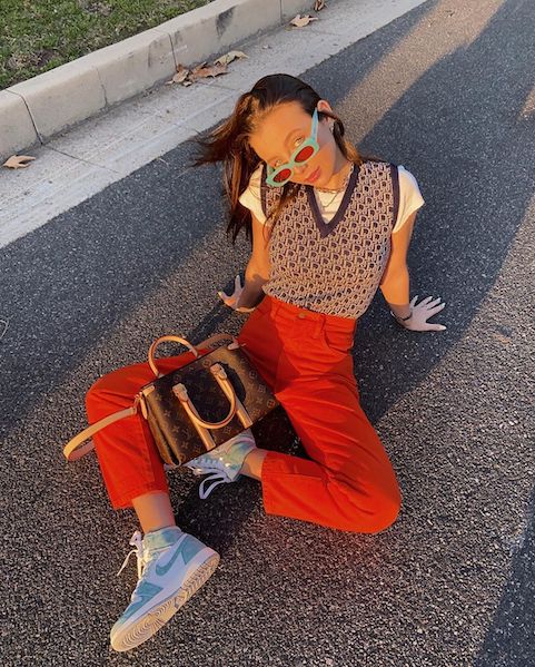 Internet favorite Emma Chamberlain tucks in her sweater vest for a more pinned look, paired with bright jeans and a head tilt made for the camera.