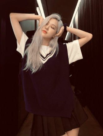 Rosé from Blackpink wears an oversized sweater vest, which pairs cutely with her black skirt.